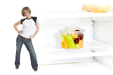 Image showing woman beside fruit cup in fridge