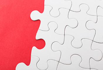 Image showing Unfinished puzzle over red background