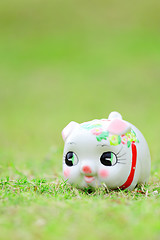Image showing Chinese piggy bank on green grass