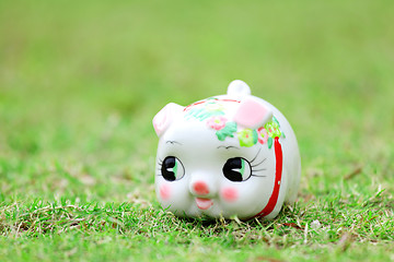 Image showing Chinese piggy bank on green lawn