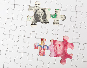 Image showing White puzzle with Chinese yuan and US dollar banknote