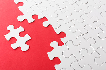 Image showing Incomplete puzzle with missing piece over red background