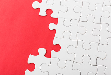Image showing White jigsaw over red background