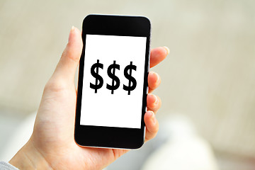 Image showing Human hand holding mobile phone with dollar sign on screen