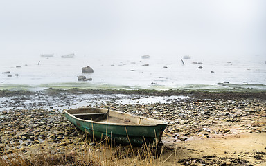 Image showing Old fishing boat at coast foggy in the morning