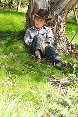 Image showing Country boy sitting under a gum tree