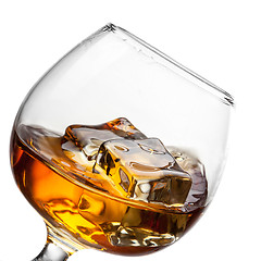 Image showing Splash of whiskey with ice in glass isolated on white background