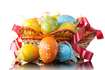 Image showing color easter eggs in basket isolated on white