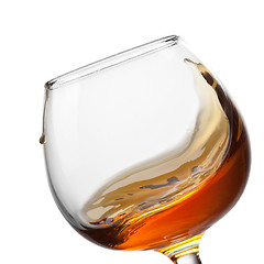 Image showing Splash of cognac in glass isolated on white background