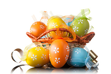 Image showing color easter eggs in basket isolated on white