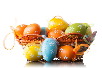 Image showing color easter eggs in basket isolated on white