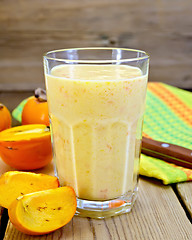 Image showing Milkshake with persimmons in glass on board