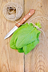 Image showing Spinach on board with knife and twine