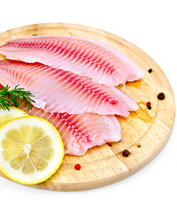 Image showing Fillets tilapia with lemon and dill on a board