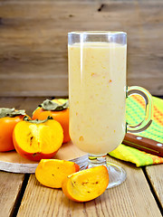 Image showing Milkshake with persimmons in goblet on board
