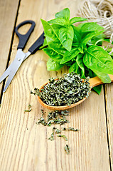 Image showing Basil green fresh and dry in spoon with scissors