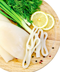 Image showing Squids with lemon and onions on a round board