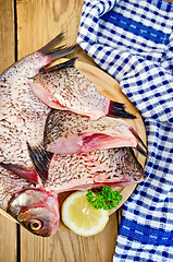 Image showing Bream raw on board with a knife and napkin