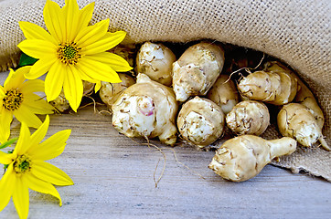 Image showing Jerusalem artichokes with burlap and flowers on board