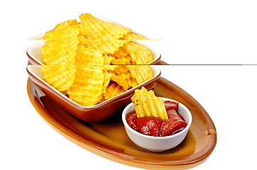 Image showing Chips in tomato sauce on a clay plate