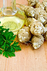 Image showing Jerusalem artichokes with carafe of oil on board