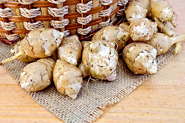 Image showing Jerusalem artichokes with a basket and burlap on board