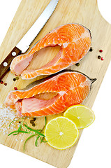 Image showing Trout with lemon and knife on plank