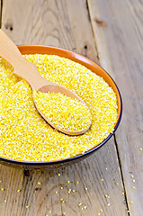 Image showing Corn grits in bowl with spoon on board