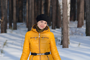 Image showing Woman in black beret b yellow jacket on forest background