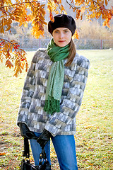 Image showing Woman in black beret and gloves holding bag.