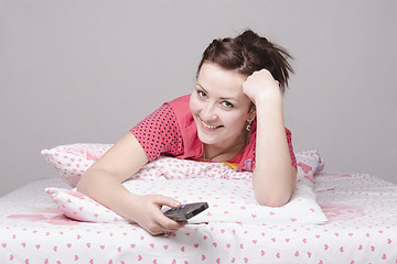 Image showing girl on bed laughing while watching TV