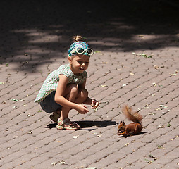 Image showing Little girl and squirrel