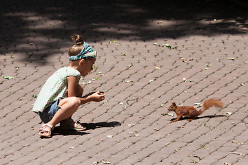 Image showing Little girl and squirrel
