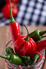 Image showing Red and green chili peppers in glass