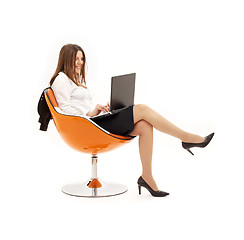 Image showing businesswoman with laptop in orange chair