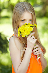 Image showing Girl smelling bunch of dandelions