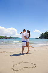 Image showing happy couple have fun on the beach with heart on sand