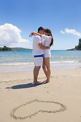 Image showing happy couple have fun on the beach with heart on sand