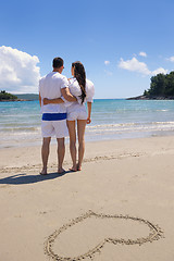 Image showing happy couple have fun on the beach with heart on sand