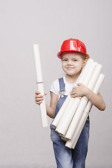 Image showing Child architect in helmet stands bunch of drawings