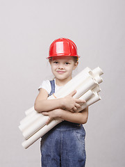 Image showing child in helmet stands with a bunch of drawings