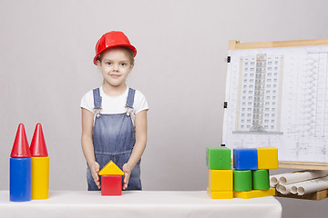 Image showing The girl is building a house on drawing