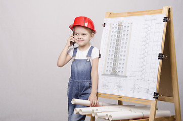 Image showing The child in helmet talking on phone