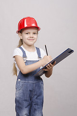 Image showing child five years worth helmet and writes in folder