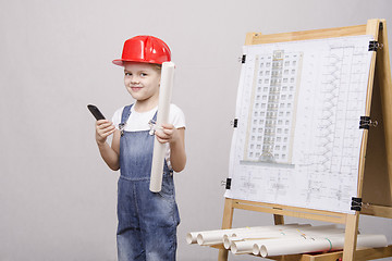 Image showing Child stands a phone at blackboard with drawing