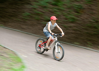 Image showing Boy racing on bike through park