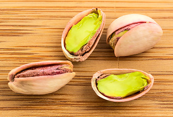 Image showing A stack of roasted pistachios on wood