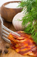 Image showing rustic still life with a slice of sausage