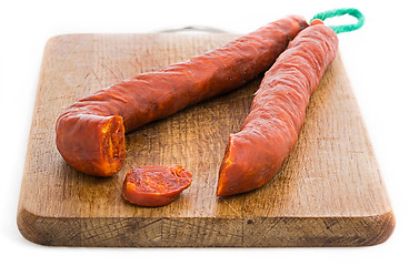 Image showing Chorizo sausage sliced on wood chopping board