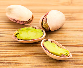 Image showing A stack of roasted pistachios on wood